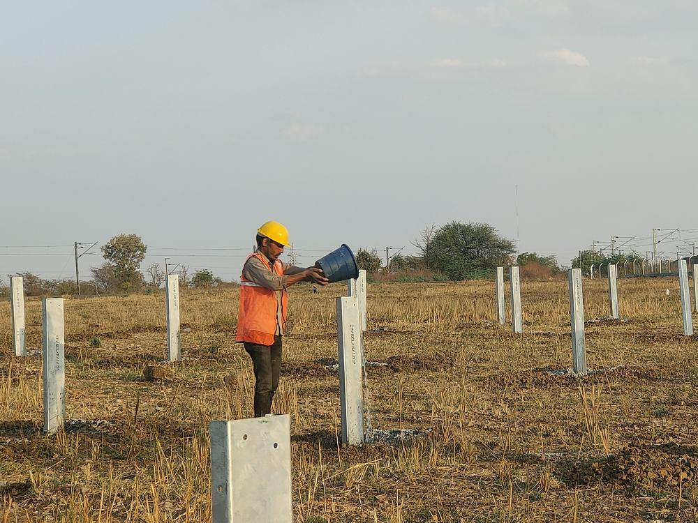 Solunar site worker in PPE curing solar piles
