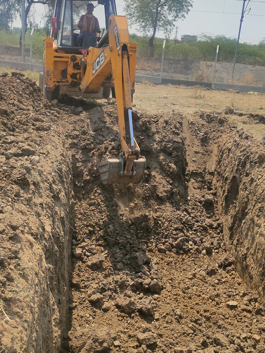 Excavator digging a cable trench on a solar site